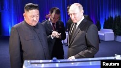 Pemimpin Korea Utara Kim Jong Un (kiri) menyerahkan pedang kepada Presiden Rusia Vladimir Putin setelah pembicaraan mereka di Vladivostok, Rusia 25 April 2019. (Foto: Sputnik/Alexei Nikolsky/Kremlin via REUTERS)