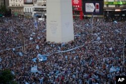 Argentina soccer fans celebrate their team's victory over Croatia in a World Cup semifinal match, by the Obelisk,in downtown Buenos Aires, Argentina, Dec. 13, 2022.