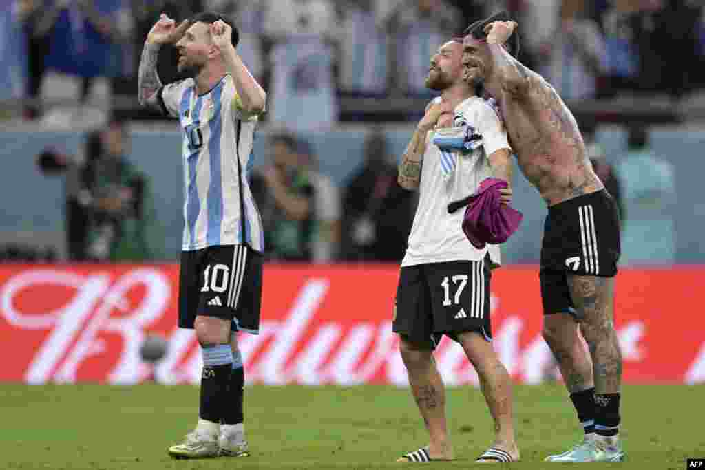 Attaquant ya Argentine Lionel Messi #10 (G) na bainga baye ba ekipi milieu #17 Alejandro Gomez (C) na #07 Rodrigo De Paul batomboli maboko koespela elonga 2-1 liboso lya Australie na 8e ya finales ya Mondial Qatar 2022 na stade Akmad Bin All, Al-Rayyan, D