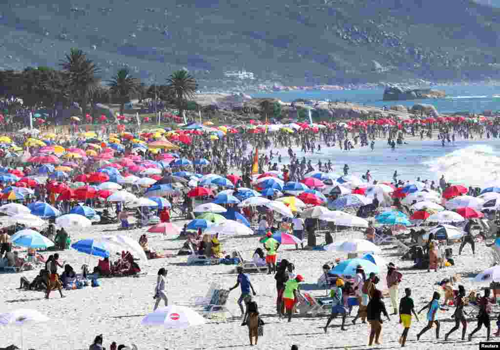 People relax and have fun on a summer day at Camps Bay beach in Cape Town, South Africa.