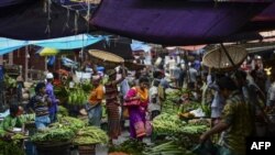 ঢাকার কারওয়ান বাজারের সবজি বাজারের মধ্য দিয়ে হেঁটে যাচ্ছেন একজন বাংলাদেশি নারী। (ফাইল ছবি) 