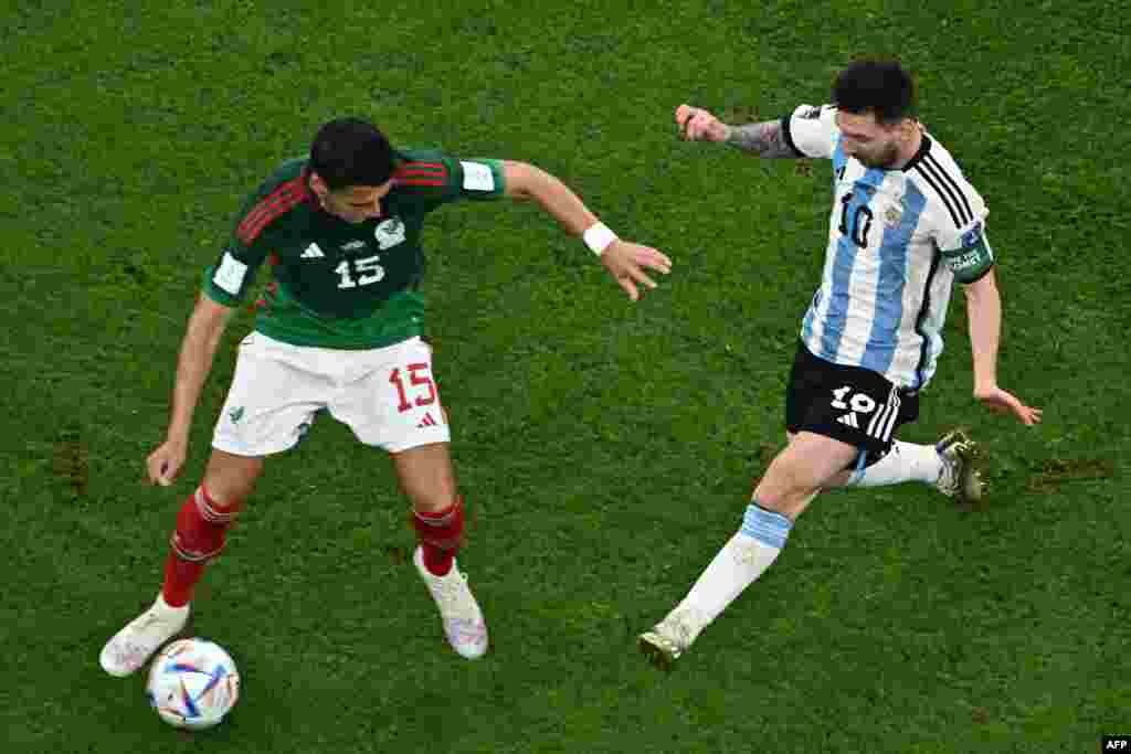 Défenseur ya Mexique #15 Hector Moreno (G) azali kowelela ndembo na attaquant ya Argentine @10 Lionel Messi (D0 na match ya groupe C ya Mondial Qatar 2022 na stade Lusail, Doha, 26 novembre 2022. (Photo MANAN VATSYAYANA / AFP)