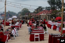 Wisatawan duduk di sebuah restoran di Pantai Jimbaran Bali, pada Sabtu, 12 November 2022. (Foto: AP)