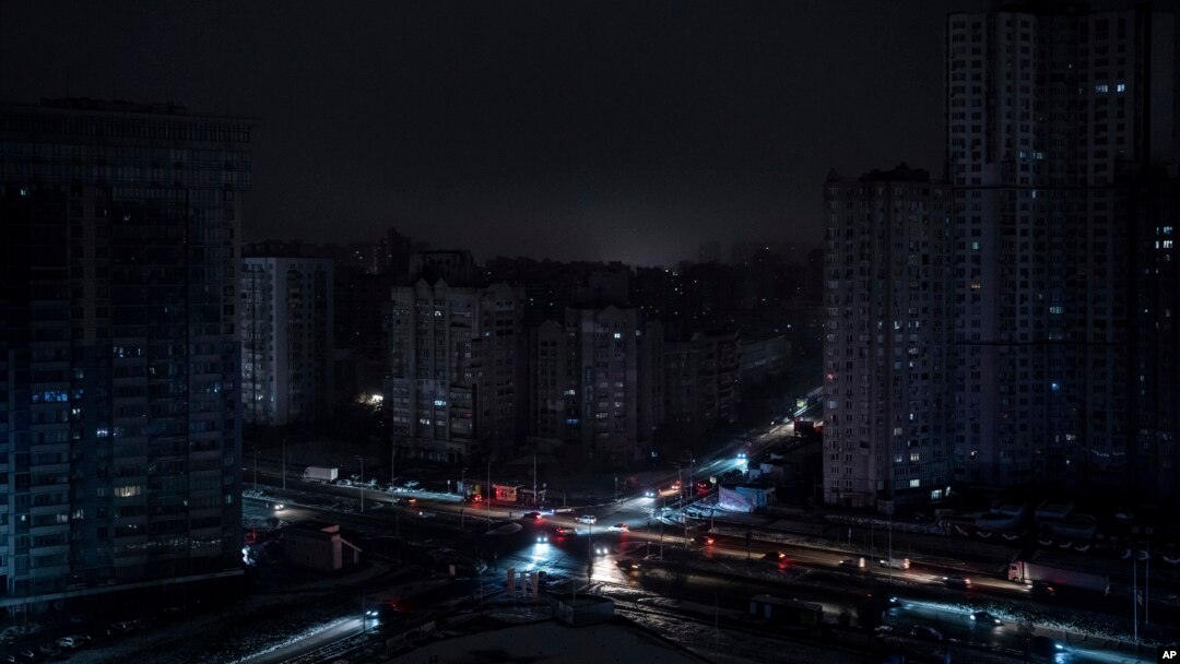 Cars drive past residential blocks which were de-energized after a Russian rocket attack in Kyiv, Ukraine, Nov. 23, 2022.