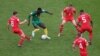 Le Camerounais Martin Hongla entouré de joueurs suisses lors du match des Lions indomptables contre la Confédération helvétique le 24 novembre 2022 au Qatar. 