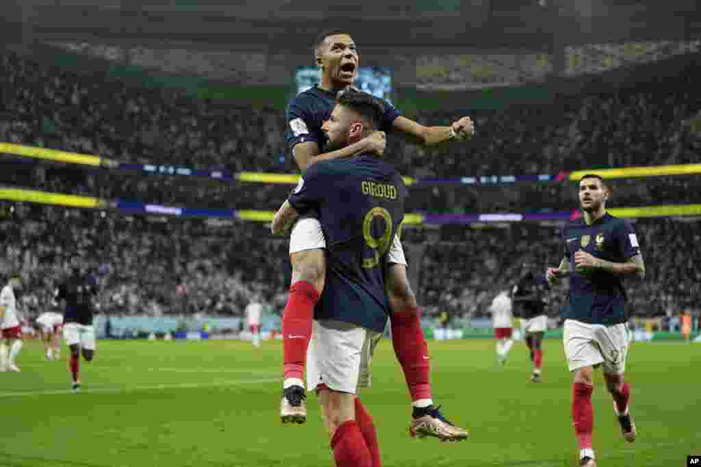 Olivier Giroud e Kylian Mbappe celebram o primeiro golo do jogo frente à Polónia ol nan ouveti match seleksyon nasyonal La Frans kont La Poloy, nan Mondyal Foutbol Qatar la, Dimanch 4 Desanm, 2022.