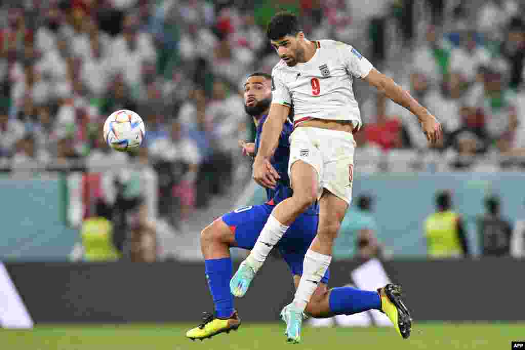 Attaquant ya Iran #09 Mehdi Taremi abeti ndembo na kowelela na défenseur ya Etats-Unis #20 Cameron Carter-Vickers na match ya groupe B ya Mndial Qatar 2022 na stade Al-Thumama, Doha, 29 novembre 2022. (Photo Glyn KIRK / AFP)