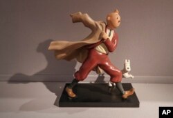 Patung resin polikrom tahun 1988 dari karakter komik Tintin dan anjingnya, Snowy, dari album "The Crab with the Golden Claws" tahun 1941 karya Herge, dipajang di rumah lelang Artcurial Paris, Prancis, Rabu, 13 Januari 2021. (AP/Michel Euler)