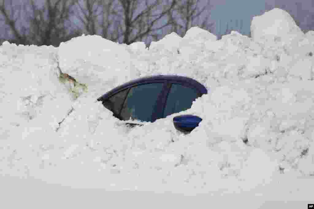 Автомобил е затрупан под снег во Бафало, Њујорк, откако зимската бура го зафати западен Њујорк.