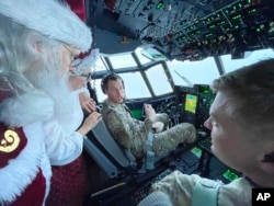 Santa and Mrs. Claus chat with the flight crew of an Alaska National Guard cargo plane while en route to Nuiqsut, Alaska, Nov. 29, 2022.