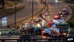 FILE - Paramedics and emergency service personnel work on the scene of a diesel tanker crash on the N12 highway in Johannesburg, January 7, 2023.