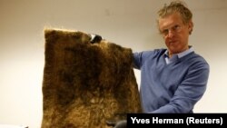 Patrick Janssen, co-founder of Dung Dung, shows a mat made from recycled human hair in Waremme, Belgium Dec. 8, 2022. REUTERS/Yves Herman