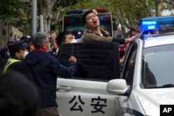 FILE - Police detain a protester during a demonstration on a street in Shanghai, China, on Nov. 27, 2022. (AP Photo, File)