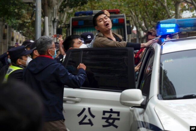 FILE - Police detain a protester during a demonstration on a street in Shanghai, China, on Nov. 27, 2022. (AP Photo, File)