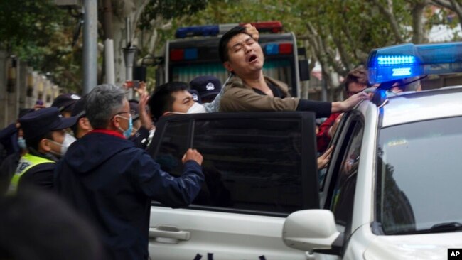 Police detain a protester during a demonstration on a street in Shanghai, China, on Nov. 27, 2022.