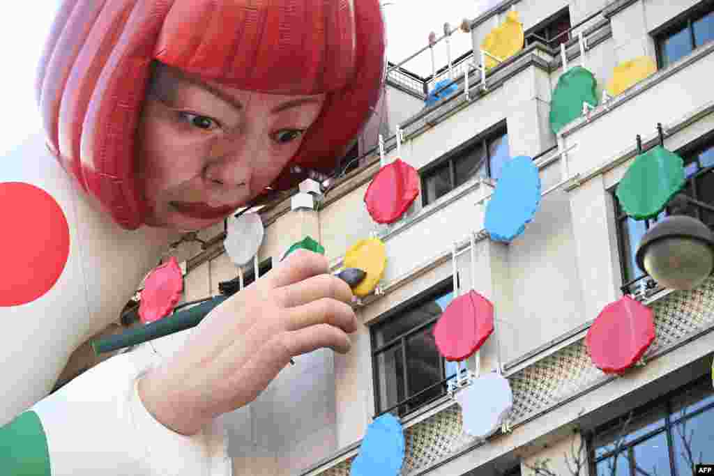 A large blow-up mannequin depicts Japanese contemporary artist Yayoi Kusama decorating the French luxury brand Louis Vuitton flagship store on the Champs-Elysees avenue in Paris.