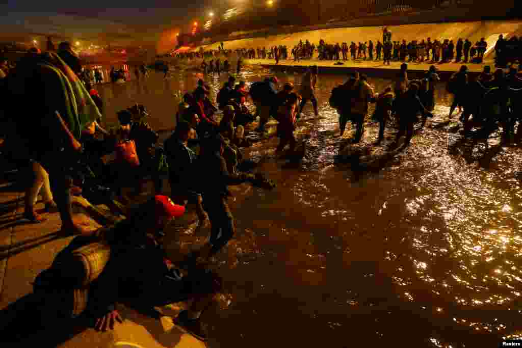 Migrants cross the Rio Bravo river to turn themselves in to U.S. Border Patrol agents in El Paso, Texas, as seen from Ciudad Juare, Dec. 11, 2022.
