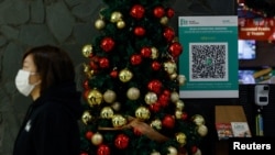 A QR code for the "LeaveHomeSafe" COVID-19 contact-tracing app is seen inside a shopping mall in Hong Kong, China, Dec 13, 202