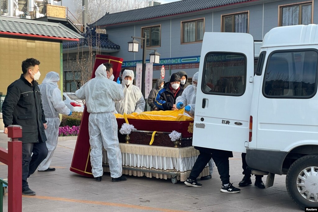 北京一家火葬场工作人员将灵柩移下车。（2022年12月17日）(photo:VOA)