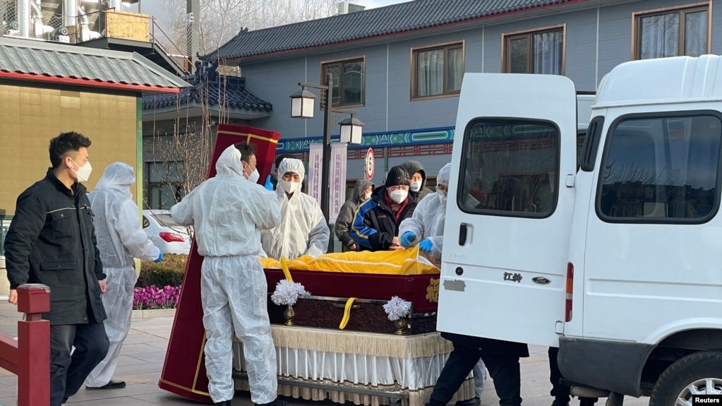 北京一家火葬场工作人员将灵柩移下车。（2022年12月17日）(photo:VOA)