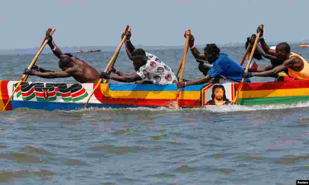 Participants paddle a boat during the traditional Isambo Beach Carnival, as part of Christmas festivities in Lake Victoria at Che's Bay near the Port Victoria town of Budalangi in Bunyala Sub-County of Busia, Kenya.