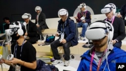 Attendees wear VR headsets while previewing the Caliverse Hyper-Realistic Metaverse experience at the Lotte booth during the CES tech show, Jan. 6, 2023, in Las Vegas. 