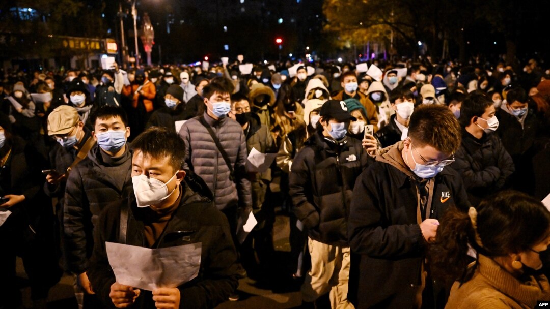 Para pengunjuk rasa berbaris di sepanjang jalan untuk berunjuk rasa terhadap pembatasan COVID-19 yang ketat di China di Beijing pada 28 November 2022. (Foto: AFP)