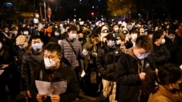 Para pengunjuk rasa berbaris di sepanjang jalan untuk berunjuk rasa terhadap pembatasan COVID-19 yang ketat di China di Beijing pada 28 November 2022. (Foto: AFP)