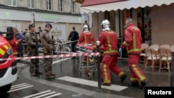 FILE - Firefighters push a gurney on a street after gunshots were fired in central Paris, France, Dec. 23, 2022, in this still image obtained form a social media video.