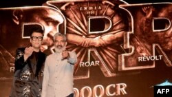 Sutradara dan produser film Bollywood Karan Johar (kiri) menghadiri acara untuk merayakan kesuksesan box office film drama aksi periode berbahasa Telugu 'RRR' yang disutradarai oleh S. S. Rajamouli (kanan) di Mumbai, 6 April 2022 ini. (SUJIT JAISWAL/AFP)