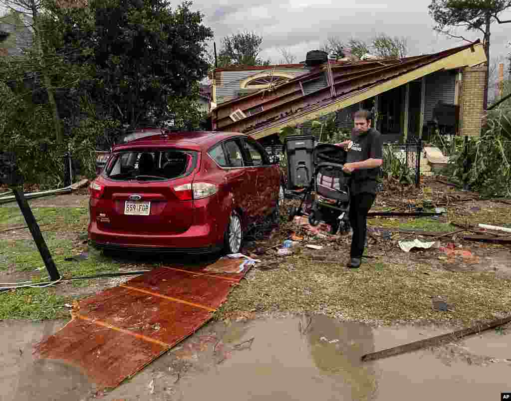 A house and car are seen damaged after a confirmed tornado on Friscoville Avenue in Arabi, Louisiana, in St. Bernard Parish, Dec. 14, 2022.