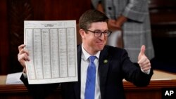 Rep. Bryan Steil, R-Wis., holds up the tally sheet in the House chamber after Rep. Kevin McCarthy, R-Calif., was elected as speaker and convene the 118th Congress in Washington, Jan. 7, 2023.