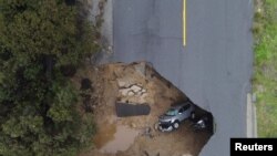 Two vehicles are seen after falling into a sinkhole in Chatsworth, California.