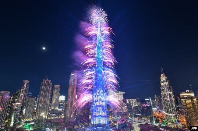 Los fuegos artificiales de Nochevieja iluminan la emblemática torre Burj Khalifa a la medianoche en el emirato del Golfo de Dubai el 31 de diciembre de 2022. [AFP]