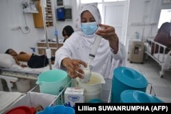 Seorang staf menyiapkan susu formula untuk pasien di bangsal malnutrisi di Rumah Sakit Boost, dijalankan oleh Medicines Sans Frontiers (MSF), di Lashkar Gah, Helmand. (Foto: AFP/Lillian SUWANRUMPHA)