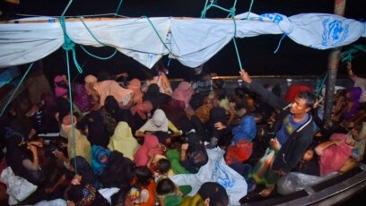 Pengungsi Rohingya duduk di perahu kayu saat tiba di Pelabuhan Krueng Geukueh di Aceh Utara, Kamis, 30 Desember 2021. (Foto: AP)