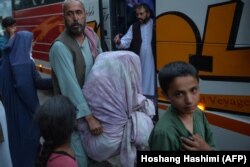 Para pengungsi bersiap naik bus untuk kembali ke tempat asalnya dengan bantuan Lembaga Swadaya Masyarakat (LSM) dan Taliban di Kabul pada 29 September 2021. (Foto: AFP/Hoshang Hashimi)