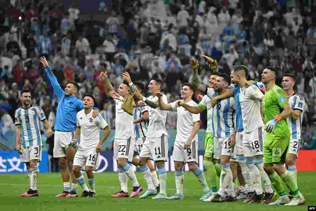 Os jogadores argentinos comemoram depois de derrotar a Croácia por 3-0 na meia-final do Campeonato Mundial de Futebol do Qatar 2022 entre Argentina e Croácia no Estádio Lusail, em Lusail, a norte de Doha, a 13 de Dezembro de 2022. (Foto de JUAN MABROMATA / AFP)
