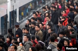 Penumpang menunggu untuk naik kereta api di stasiun kereta api di Nanjing, Provinsi Jiangsu, China timur. (Foto: Reuters)