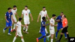 Pemain Iran berbicara dengan wasit Antonio Mateu, dari Spanyol, saat pertandingan sepak bola grup B Piala Dunia antara Iran dan Amerika Serikat di Stadion Al Thumama di Doha, Qatar, Rabu, 30 November 2022. (AP Photo/Luca Bruno)