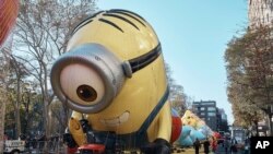 Seorang pria mengambil foto balon karakter Stuart Minion yang berada di jalanan Kota New York, pada 23 November 2022. Balon tersebut dipersiapkan untuk parade Thanksgiving Macy's yang digelar pada 24 November 2022. (Foto: AP/Andres Kudacki)