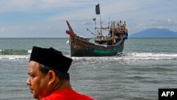 A man stands near a boat used by Rohingya refugees to arrive in Lamnga beach, Aceh province, Indonesia.&nbsp;A wooden boat carrying nearly 200 Rohingya refugees, a majority of them women and children, landed on Indonesia&#39;s western coast, police said.