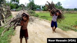 Two Rohingya children carrying firewood to their refugee camp home in Cox’s Bazar, Bangladesh. Like most other children of their community, they do not have proper access to formal education in the Bangladesh camps.