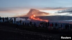 People gather to observe the eruption of the Mauna Loa volcano in Hawaii, Dec. 1, 2022.
