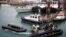 FILE: Members of Britain's Border Force tow into the Port of Dover an inflatable boat used by migrants who were rescued while crossing the English Channel, in Dover, UK. Taken April 14, 2022. 