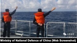 Các thành viên của lực lượng hải quân Trung Quốc vẫy tay chào tạm biệt các đối tác Việt Nam sau khi kết thúc cuộc tuần tra chung hai ngày trên Vịnh Bắc Bộ hôm 25/11.