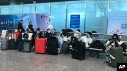 Inbound travelers wait to board buses to leave for quarantine hotels and facilities from Guangzhou Baiyun Airport in southern China's Guangdong province on Dec. 25 2022. 