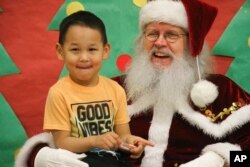 Santa Claus poses with a child at the Trapper School in Nuiqsut, Alaska, Nov. 29, 2002.