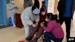 A patient with Covid-19 coronavirus is assisted at Fengyang People's Hospital in Fengyang County in east China's Anhui Province on Jan. 5, 2023. 