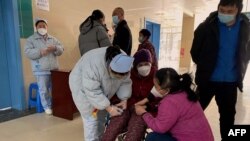 Un paciente con coronavirus Covid-19 recibe asistencia en el Hospital Popular de Fengyang en el condado de Fengyang, en la provincia oriental china de Anhui, el 5 de enero de 2023.